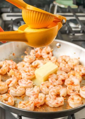 Overhead shot of garlic butter shrimp and buttery pasta in a white dish