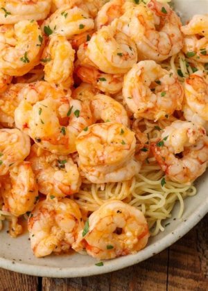 Overhead shot of garlic butter shrimp and buttery pasta in a white dish