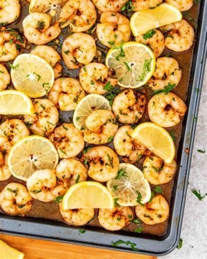 Overhead vertical shot of garlic butter shrimp and buttery pasta, served in a white bowl