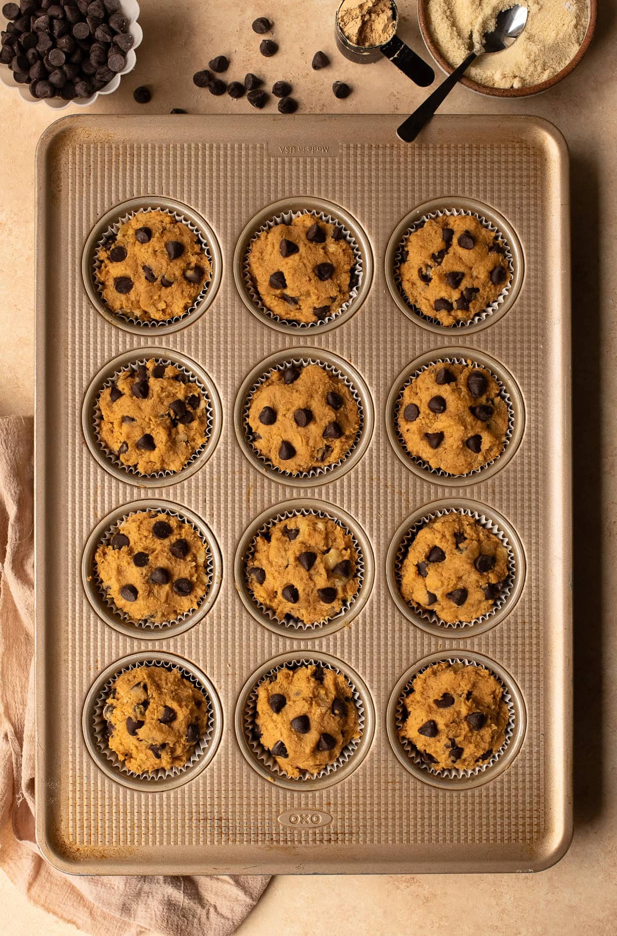 Muffin batter portioned into muffin pan cups prior to baking.