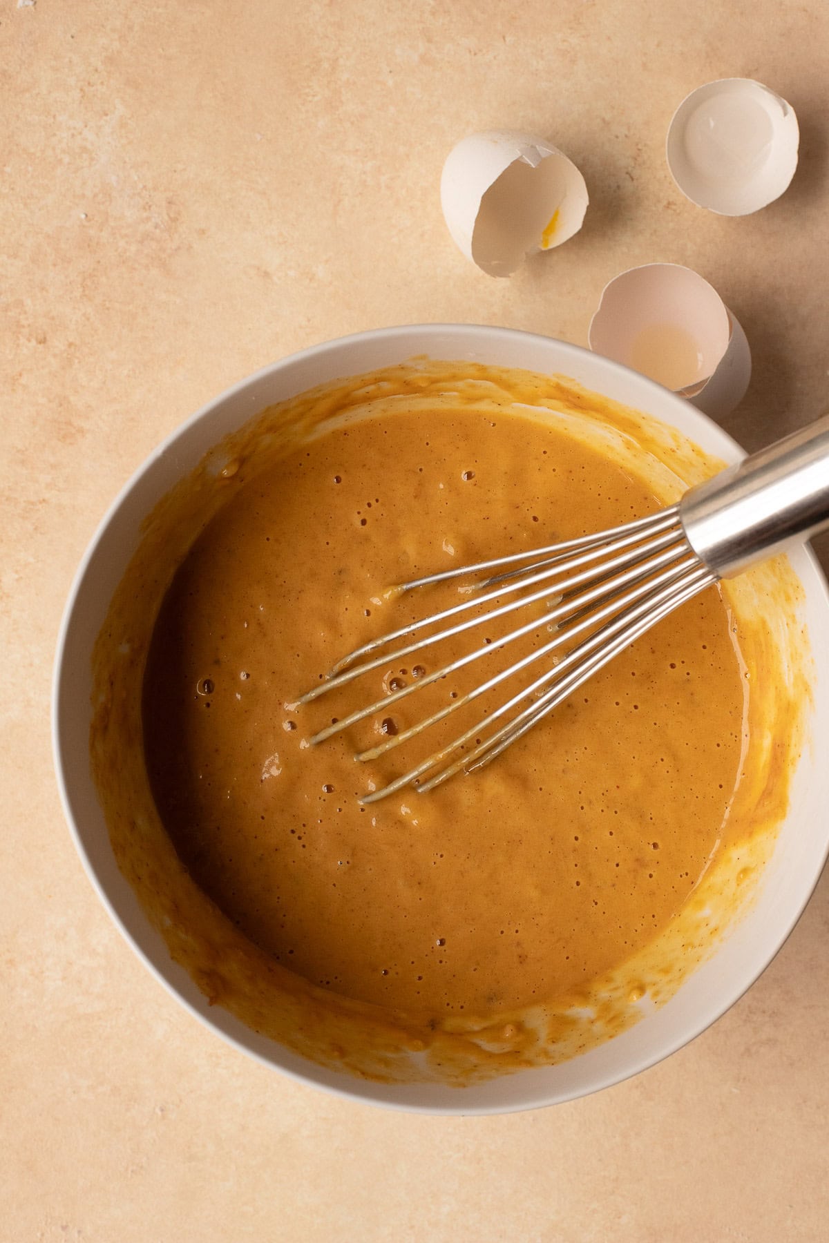 Wet ingredients for muffins whisked together in a bowl.